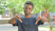 © stockbakers - Casual African Man Giving Thumbs Down Outdoors