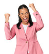 © Asier - Young Filipina in pink suit raising fist after a victory, winner concept.