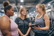 © Vlad - College Gym: Trainer Assisting Overweight Women in Fitness Class for Healthy Weight Loss and Friendship
