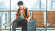 © oatawa - Happy asian tourist man using mobile smartphone with suitcase traveling between waits for flight in Airport Terminal, Browse Internet, flight check in, Tourist journey trip concept, copy space