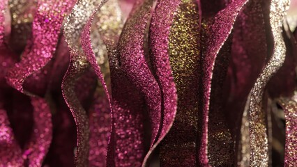 Wall Mural - Pink and gold glittering ribbons create a mesmerizing visual effect, gently waving and swirling, their metallic surfaces catching and reflecting light