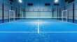 © Farhan - A modern indoor sports facility with an empty blue padel court under bright lights, ready for a recreational game or professional tournament.
