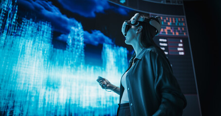 Female Urban Designer Immersed in Virtual Reality, Reimagines a Futuristic City. Virtual Production Screen Displays a Cityscape Polygon Model that is Transformed and Manipulated