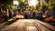 © Viral - Rustic wooden table in focus, warm evening party blurred background, inviting summer gathering atmosphere.