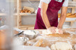 © JackF - Elderly baker hands kneading dough on table, close-up