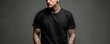 © ParinApril - Portrait of a tattooed man with a serious expression wearing a black t-shirt against a neutral background highlighting intricate body art and fashion style