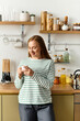 © LIGHTFIELD STUDIOS - Joyful moment in a cozy home kitchen with a beautiful woman enjoying her warm drink