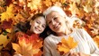 © saokaew - Grandmother and granddaughter relaxing and laying in colorful autumn leaves enjoying a beautiful fall day