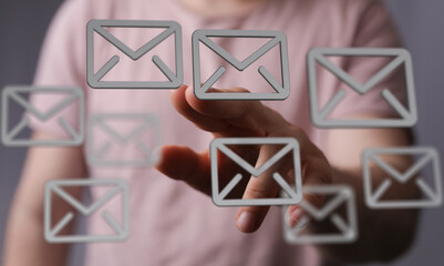 Hand interacting with floating email icons, digital communication concept.