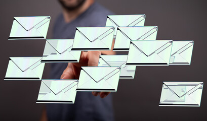 Image of a man interacting with a digital representation of multiple emails.  Concept of online communication, email marketing.