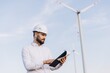 © anatoliycherkas - Engineer inspecting wind turbines for sustainable energy production