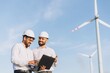 © anatoliycherkas - Engineers using laptop analyzing wind turbines in a wind farm
