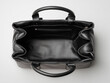 © Iryna - Black leather briefcase open, top view, stands on white background.