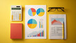 © Mahmud - Flat Lay of Calculator, Charts and Business Reports at Top view of a desk covered with a calculator, colorful pie charts, bar graphs, and printed reports