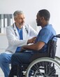 © ANATTA - Compassionate doctor consoling a black male patient in a wheelchair, offe support and empathy du a consultation in a modern clinic setting, carefully listening.