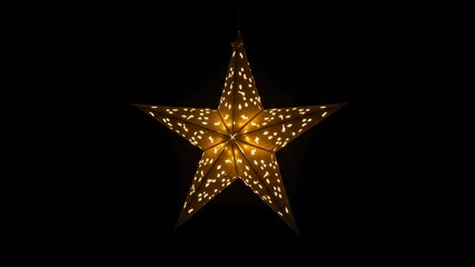 Wall Mural - glowing gold star ornament hanging in darkness for festive celebration