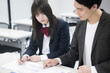 © kapinon - 学生の面談や個別指導、進路指導の塾などのイメージの先生と生徒　目指せ大学受験の合格～！机で勉強
