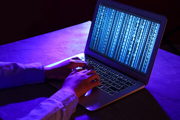 Wall Mural - female programmer typing on laptop keyboard at night in office, closeup
