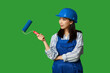 © Pixel-Shot - Female Asian painter with roller on green background