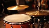 Close-up of a drum kit, showcasing a snare drum, bass drum, and cymbals in a dimly lit setting