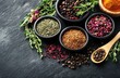 © Aranya - Composition of colorful ground spices and dried herbs on dark stone