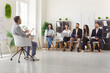 © Studio Romantic - Meeting room gathering, leader man presenting lecture talking with diverse hr group of people sitting and listening, training session, learning and collaboration, attentive engagement in coaching