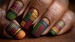 © Mehram - Kwanzaa nails with red, green, and black kinara designs on a blurred warm earthy background