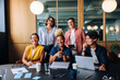 © (JLco) Julia Amaral - Group of young professionals laughing together at a meeting in an office
