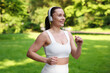 © New Africa - Sporty woman with headphones running in park