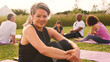 © Monkey Business - Portrait Of Mature Woman On Outdoor Yoga Retreat With Friends And Campsite In Background