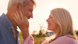 © Monkey Business - Close Up Of Loving Mature Couple In Countryside Hugging Head To Head Against Flaring Sun