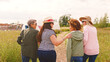 © Monkey Business - Rear View Of Group Of Mature Female Friends Walking Arm In Arm Along Path Through Yurt Campsite