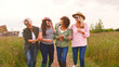© Monkey Business - Group Of Smiling Mature Female Friends Walking Arm In Arm Along Path Through Yurt Campsite
