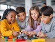 © Lubos Chlubny - Elementary school students building robot from colorful blocks in stem class