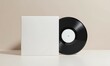 © Oak - Black vinyl LP record standing next to its blank white album cover. A clean, retro-style mockup template for showcasing music artwork or branding, set against a minimalist beige backgr
