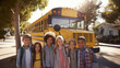 © Elena - Smiling schoolchildren standing in front of yellow school bus