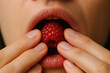 © Sebastian - The Taste of Sweetness: A close-up shot focuses on a mouth about to indulge in a juicy raspberry. The image is a sensory feast, showcasing the raw pleasure of enjoying fresh, ripe produce.