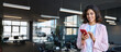 © Stock 4 You - European business woman manager using cell phone mobile application standing indoors in office. Latin Hispanic young female businesswoman entrepreneur focused working on smartphone. Banner, copy space
