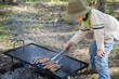 © Austockphoto - Young boy helping cook snags on the hot plate