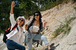 © saltdium - Two active senior women hiking on a rocky slope, holding hands and smiling confidently. Healthy outdoor lifestyle and friendship