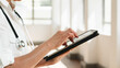 © Meeko Media - Healthcare Professional Using a Digital Tablet for Patient Information Management in a Bright Medical Clinic
