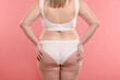 © New Africa - Weight loss. Plus size woman in underwear on pink background, closeup
