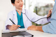 © Fahng - Consultation, patient and doctor in office with stethoscope, checkup and healthcare at clinic. Diagnosis, patient and medical professional with support, checking heart health and advice.