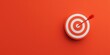 © Passakorn - target, focus, execution A dart hits the center of a red and white target on a vibrant orange background.