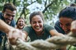 © Ilia - Energetic group tug-of-war outdoors: mixed young adults engaged in fun challenge