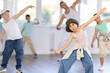 © JackF - Portrait of confident tween girl hip hop dancer training during group dance class in modern dance studio