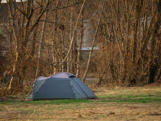 Wall Mural - Home less family tent in a park with town houses in the background behind trees. High cost of living. Poor and rich concept. Social imbalance and issue.