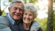 © natakot - Joyful elderly couple embracing in a sunlit park