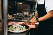 © Leah Flores/Stocksy - A Cook Cutting Steak for a Salad Dish at a Restaurant Kitchen