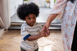 © Jovo Jovanovic/Stocksy - Young boy holding hands with adult in a quiet moment